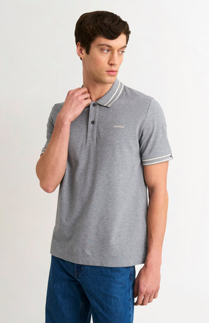 Man wearing a gray polo shirt with white trim on a plain background