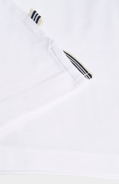 Close-up of a white polo shirt with black and white striped details on a light gray background