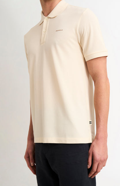 Beige polo shirt worn by a person on a light gray background