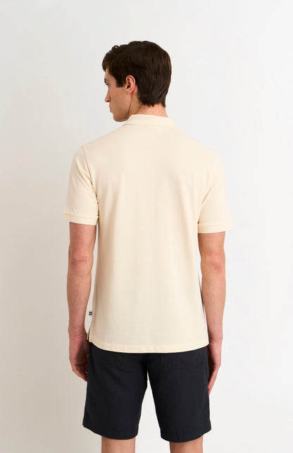 Man wearing a beige polo shirt and black shorts on a white background