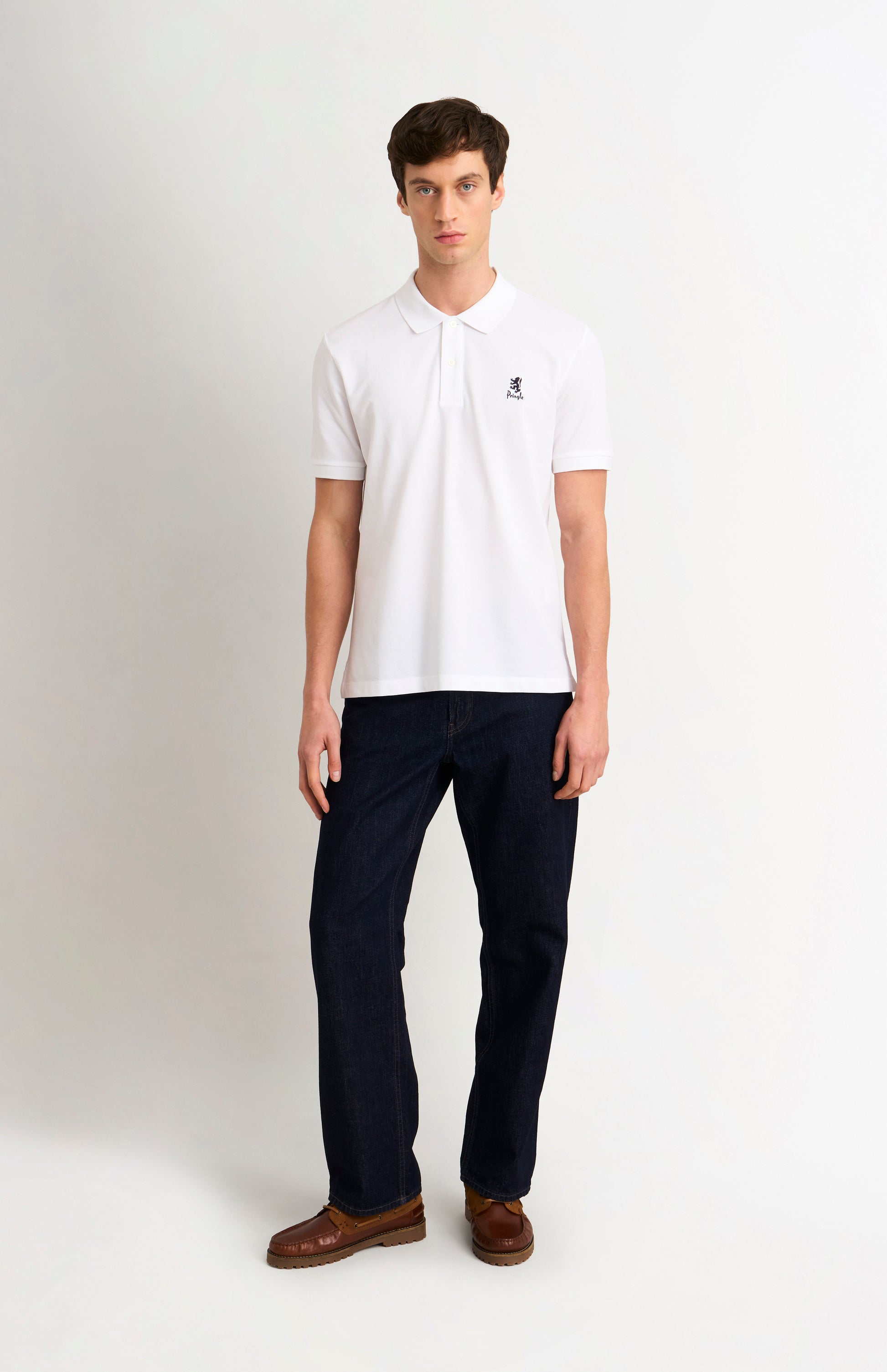 Man wearing a white polo shirt and dark pants on a white background
