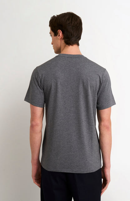 man wearing a charcoal t-shirt and black trousers on a white background