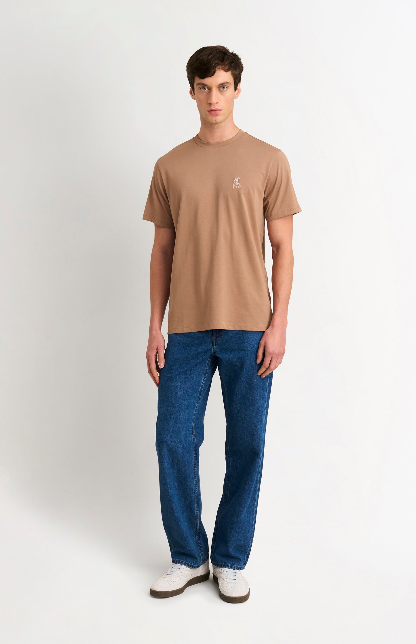 Man wearing a brown t-shirt and blue jeans