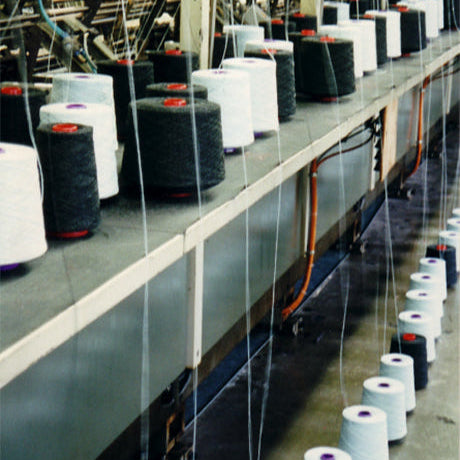 Pringle knitting factory with spools of yarn on a knitting frame.
